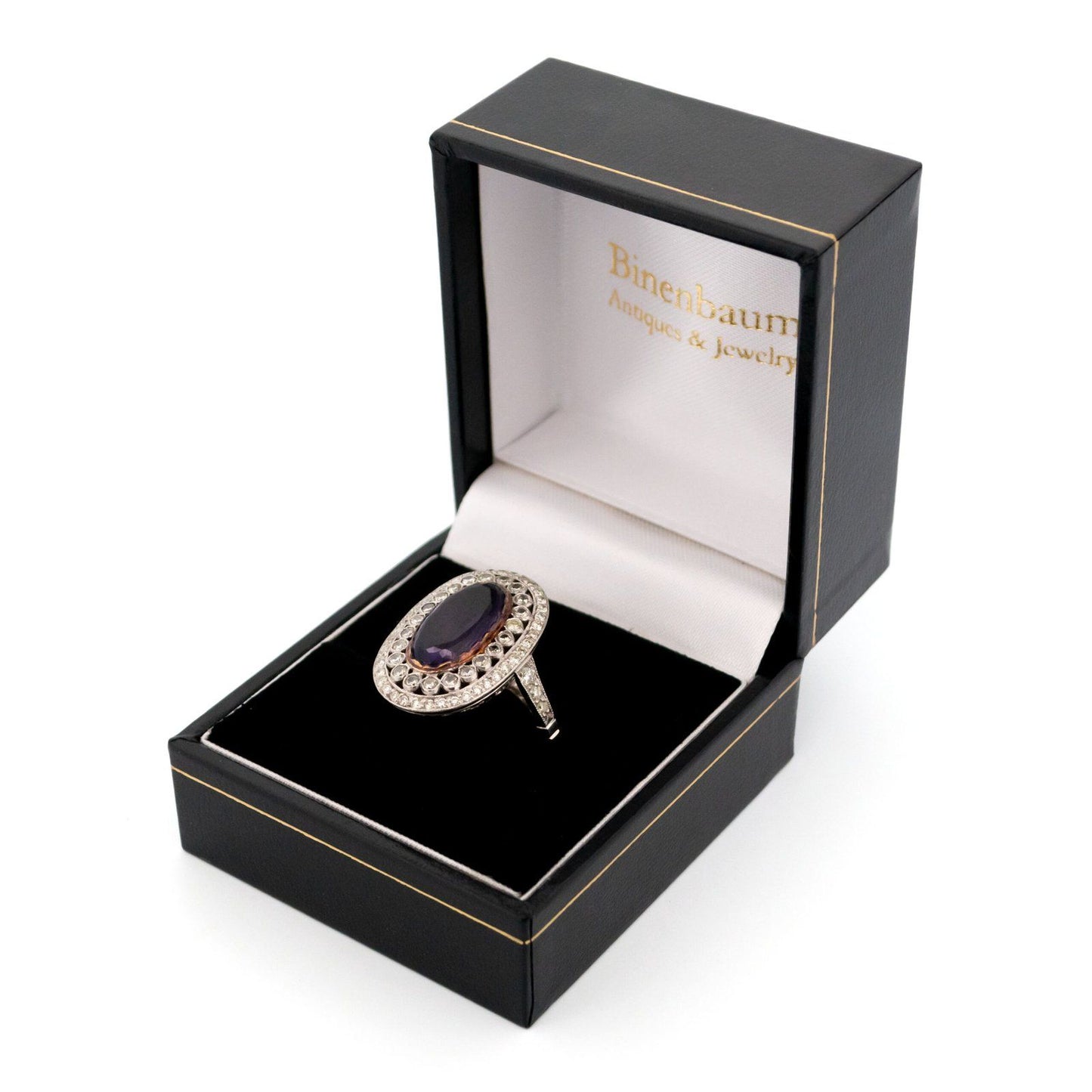 An oval shaped cluster ring with an amethyst centre and diamond surround, in platinum, in a ring box