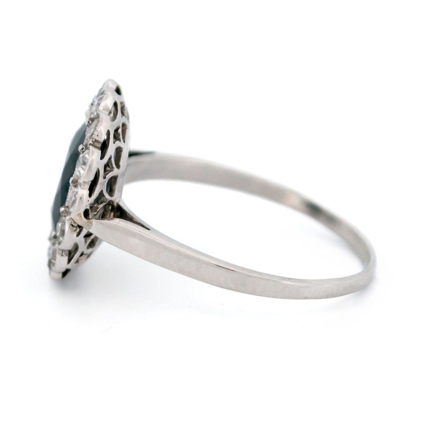 A flower shaped cluster ring set with a central sapphire surrounded by a halo of round diamonds, in platinum
