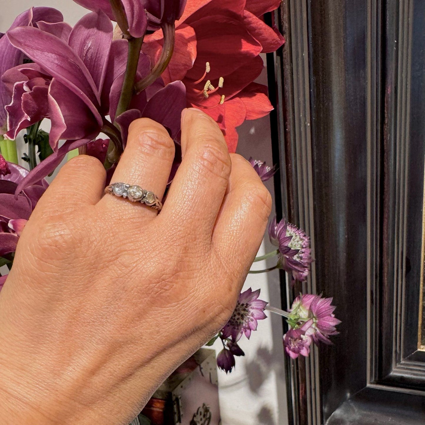A yellow gold and silver rose cut diamond three stone ring, modelled on a hand