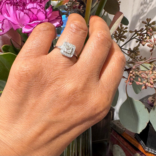A square shaped diamond cluster ring in platinum, modelled on a hand