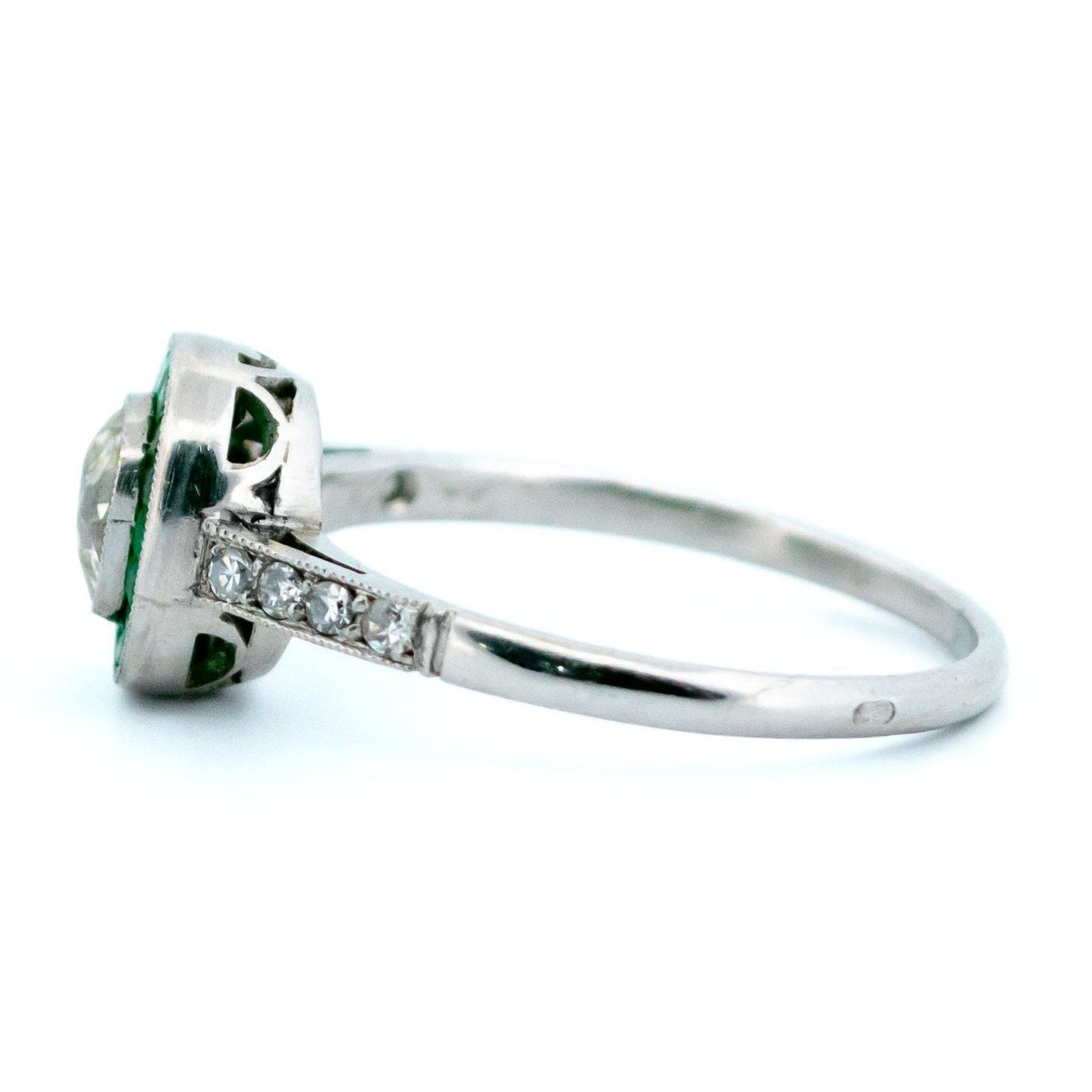 An emerald and diamond halo target cluster ring in platinum