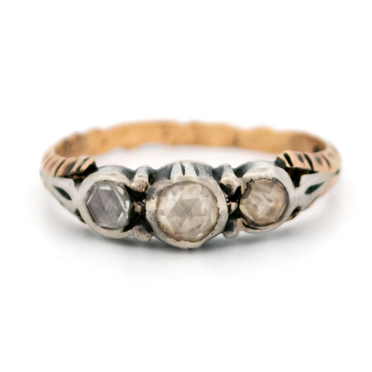 A yellow gold and silver rose cut diamond three stone ring