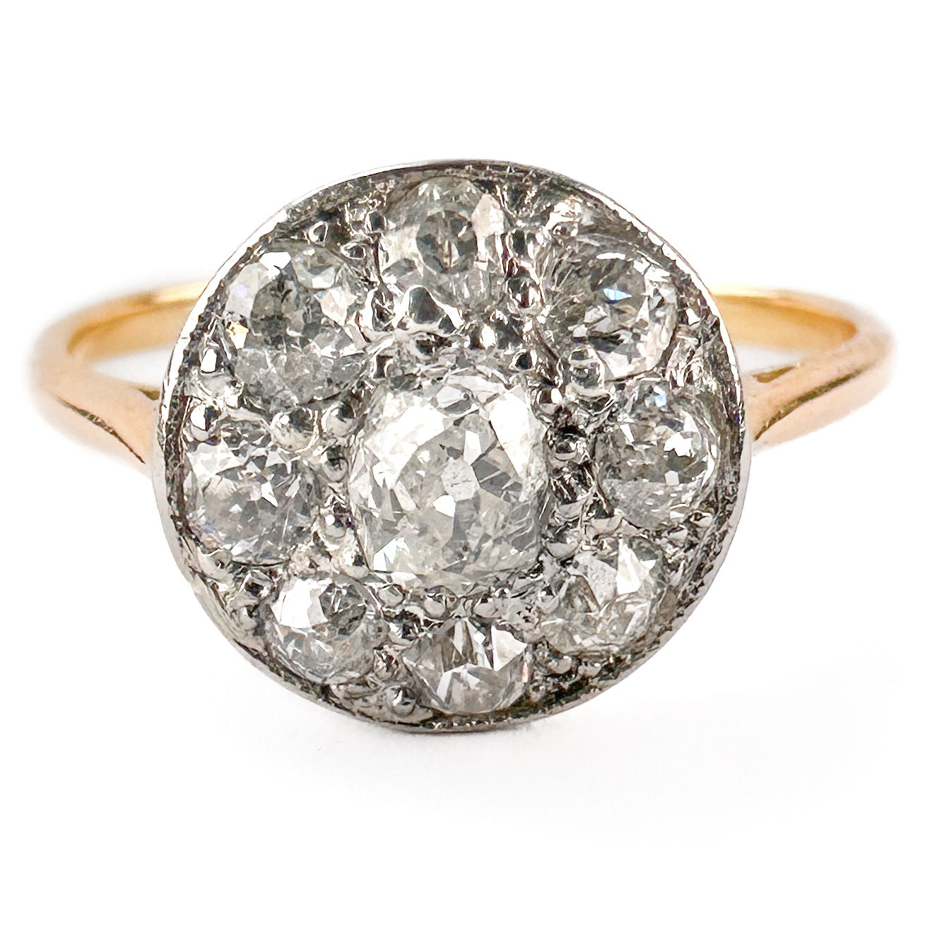 A circular cluster ring set with old cut diamonds in platinum and yellow gold