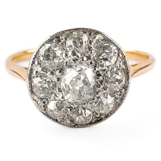 A circular cluster ring set with old cut diamonds in platinum and yellow gold