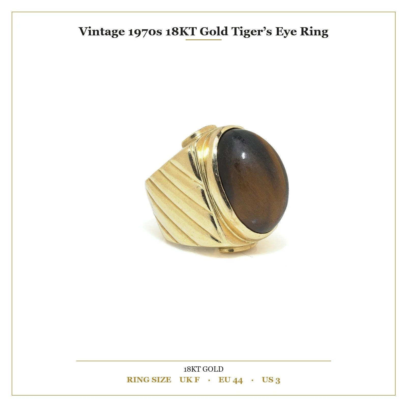 A yellow gold ring with an oval cabochon cut tiger's eye, with measurements