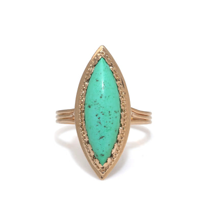A navette shaped turquoise single stone ring in yellow gold