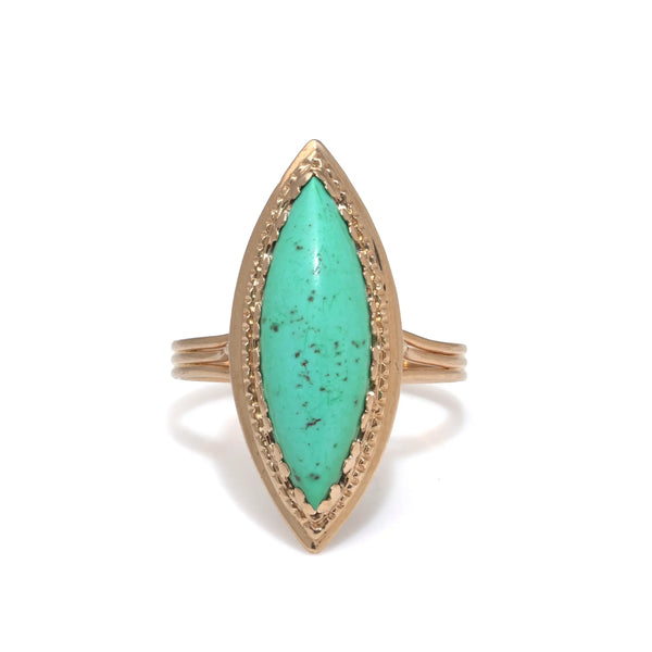 A navette shaped turquoise single stone ring in yellow gold