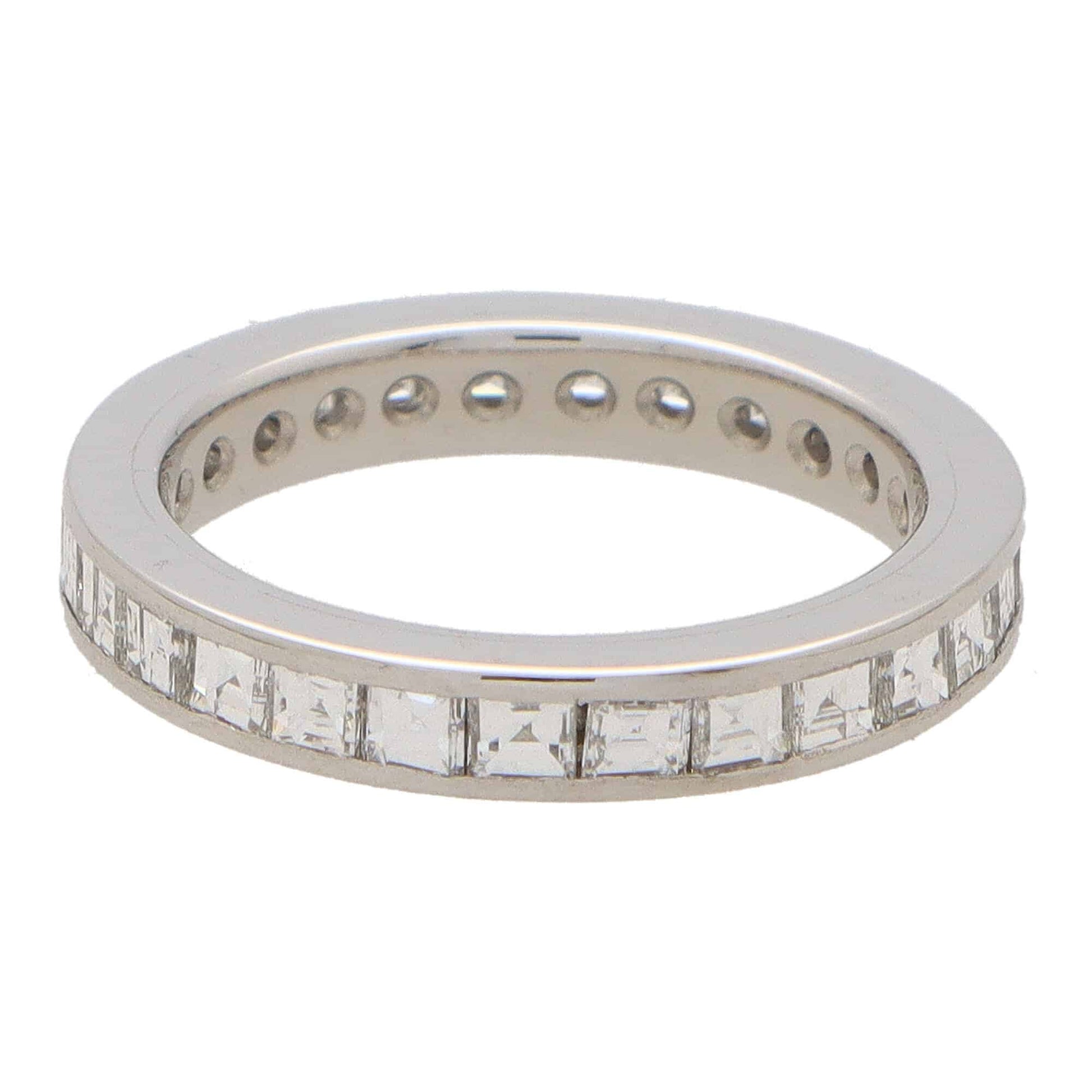 A square shaped diamond and platinum eternity ring, on a white background