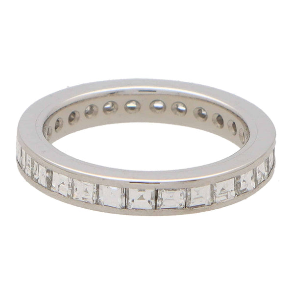 A square shaped diamond and platinum eternity ring, on a white background