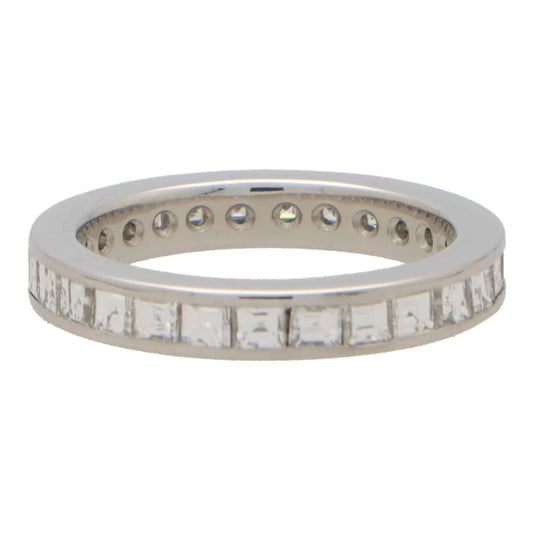 A square shaped diamond and platinum eternity ring, on a white background