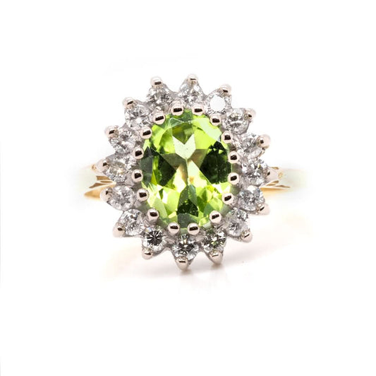 An oval peridot and diamond cluster ring in yellow and white gold