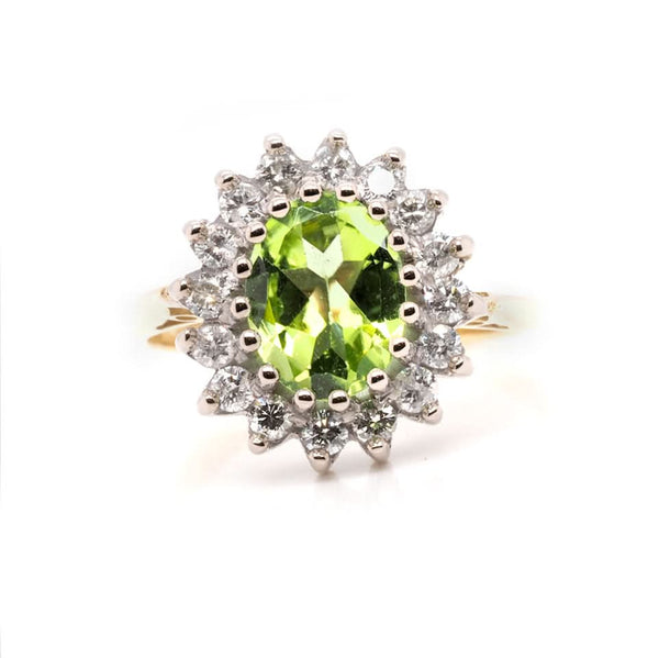 An oval peridot and diamond cluster ring in yellow and white gold