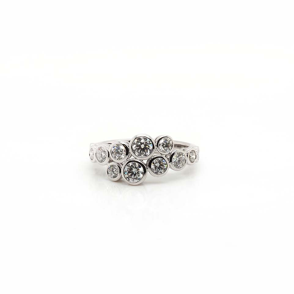 A brilliant cut diamond rubover set crossover ring with twelve diamonds, in white gold
