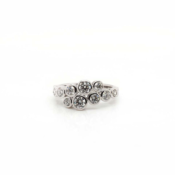 A brilliant cut diamond rubover set crossover ring with twelve diamonds, in white gold