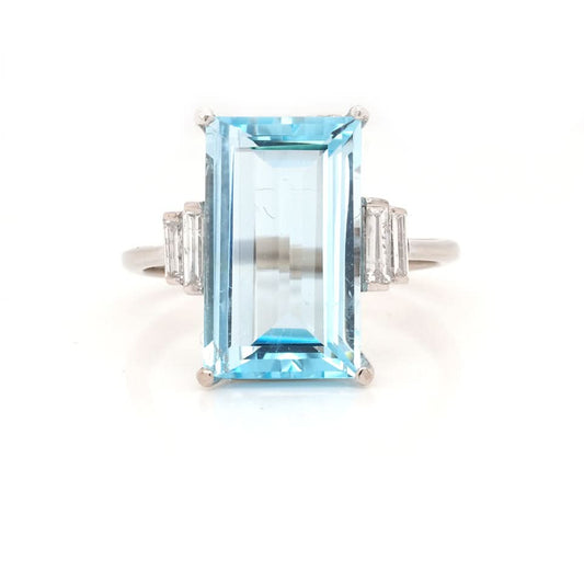 A white gold blue topaz and baguette cut diamond cocktail ring
