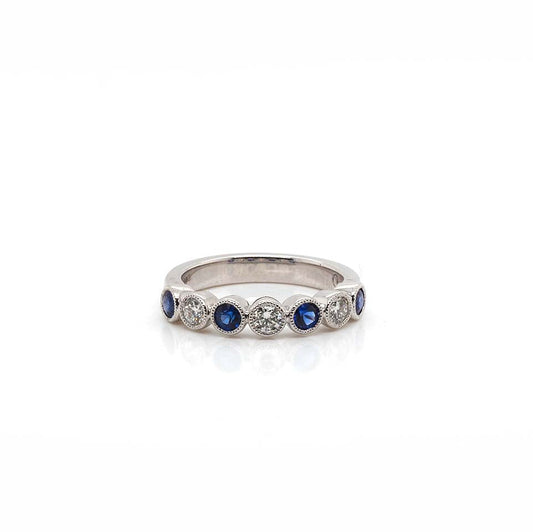 A white gold sapphire and diamond seven stone half eternity ring
