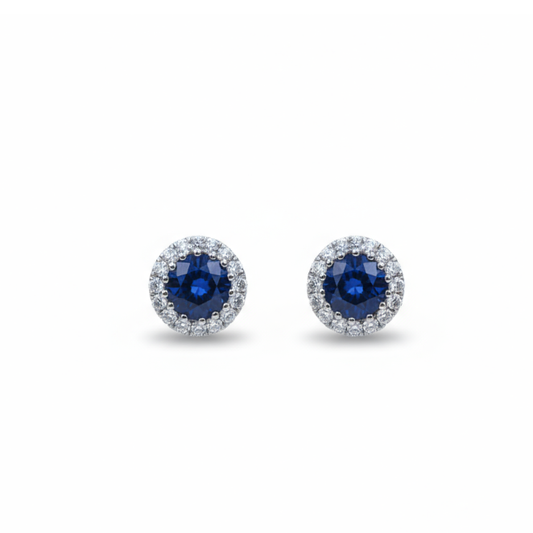 A pair of round cluster stud earrings in white gold with sapphires and diamonds