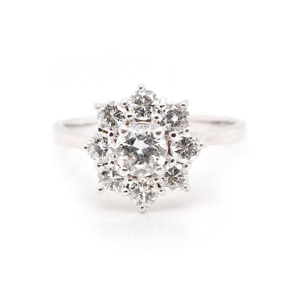 A white gold round cut diamond floral cluster ring