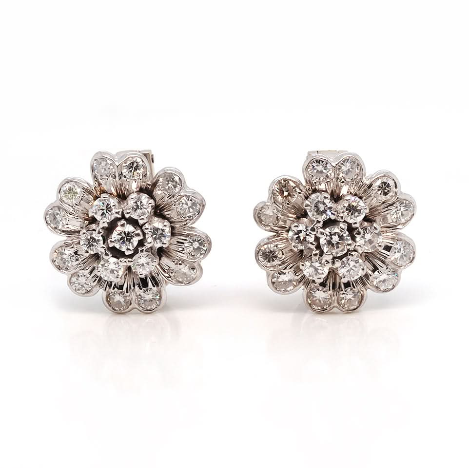 A pair of white gold flower cluster earrings with diamonds