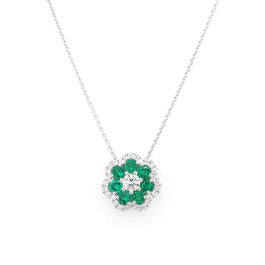 An emerald and diamond cluster pendant on a white gold chain