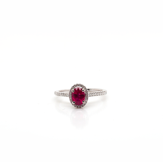 A white gold oval ruby and diamond cluster ring with diamond shoulders