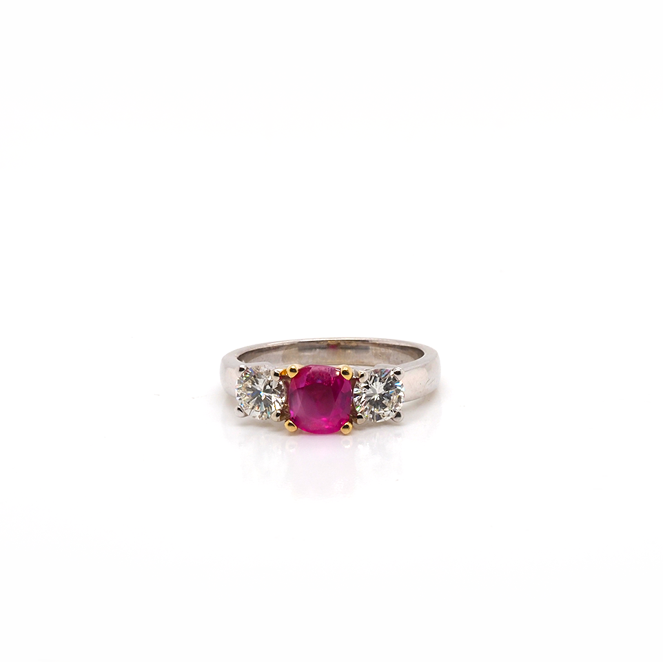 A three stone round ruby and brilliant cut diamond ring in white and yellow gold