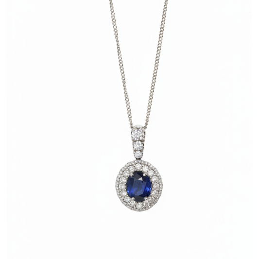 An oval cluster pendant with a sapphire centre and diamond surround, in white gold, with a white gold chain