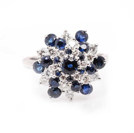 A sapphire and diamond swirl cluster ring in white gold