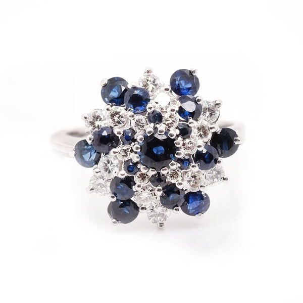 A sapphire and diamond swirl cluster ring in white gold