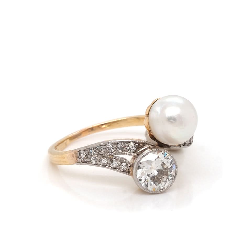 A pearl and diamond fancy crossover ring in yellow and white gold