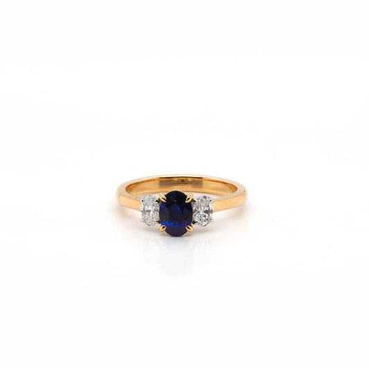 An oval sapphire and oval diamond three stone ring in yellow and white gold