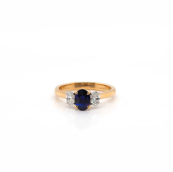 An oval sapphire and oval diamond three stone ring in yellow and white gold