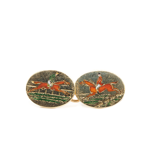 A yellow gold oval cufflink depicting two jockeys on horseback in enamel