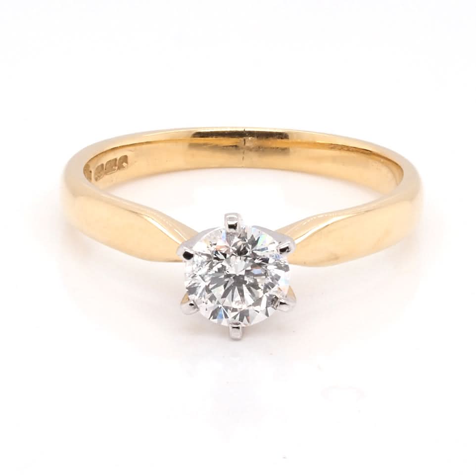 A solitaire brilliant cut diamond ring in yellow and white gold