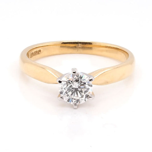 A solitaire brilliant cut diamond ring in yellow and white gold