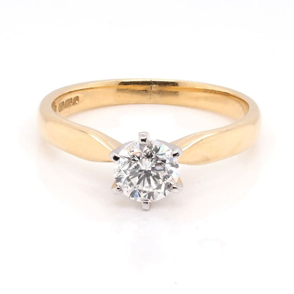 A solitaire brilliant cut diamond ring in yellow and white gold