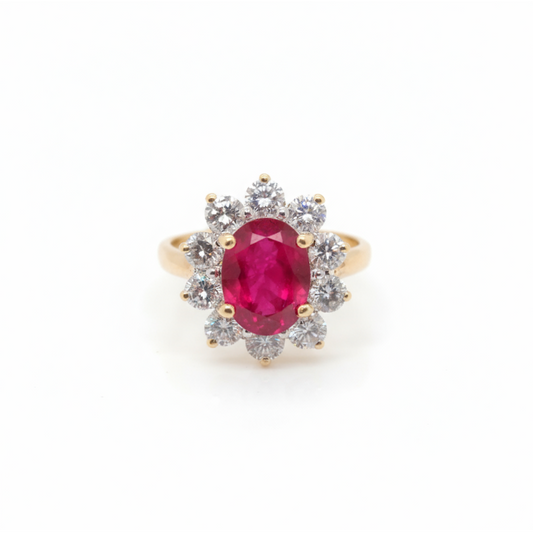 A yellow gold ruby and diamond oval cluster ring