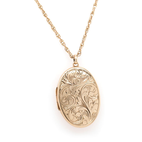 An oval yellow gold engraved locket, on a yellow gold chain