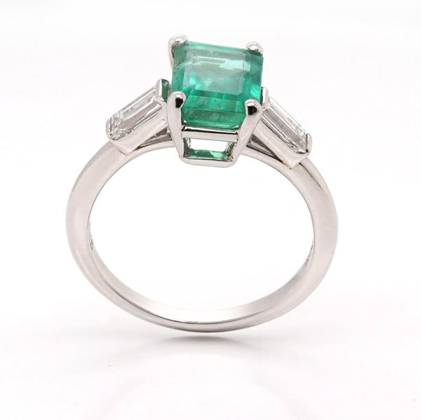 A three stone emerald and diamond ring in platinum