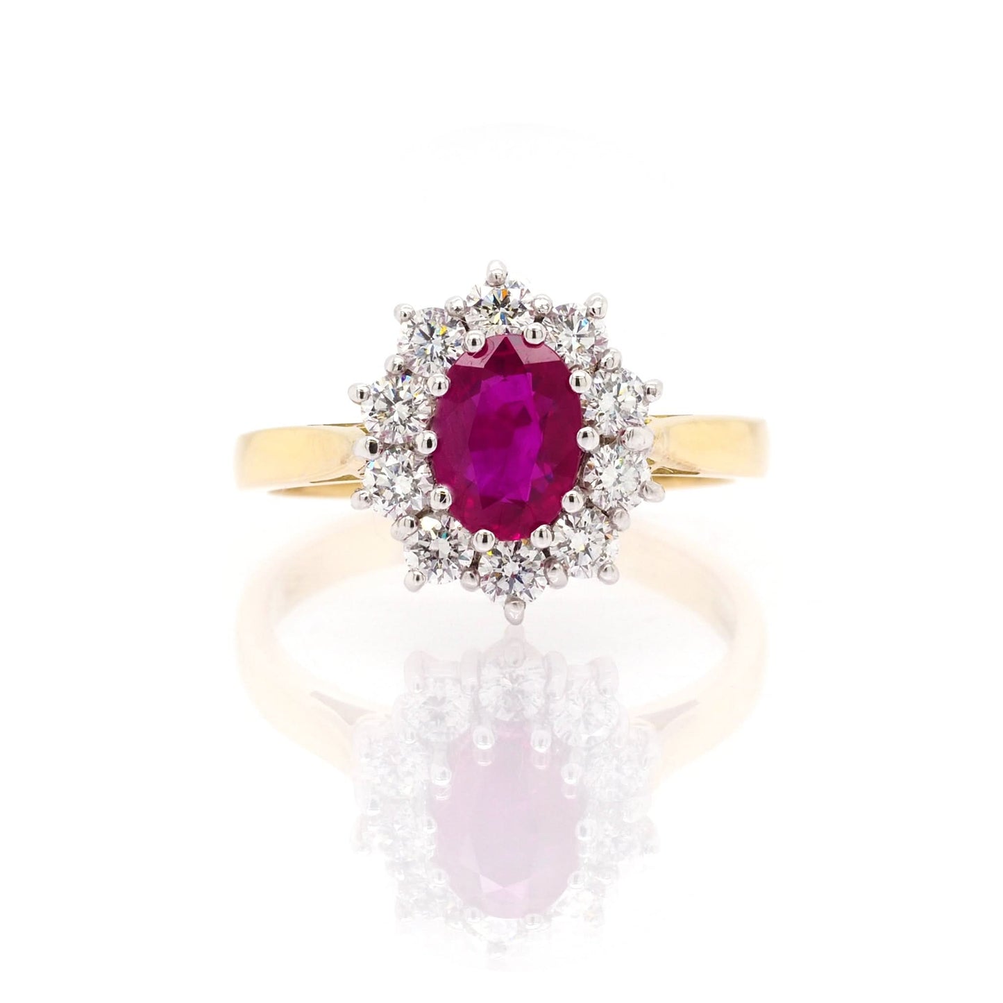 An oval ruby and diamond oval shaped cluster ring in yellow and white gold
