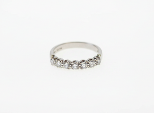 A seven stone brilliant cut diamond half eternity ring in platinum