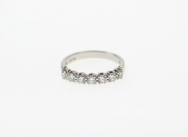 A seven stone brilliant cut diamond half eternity ring in platinum