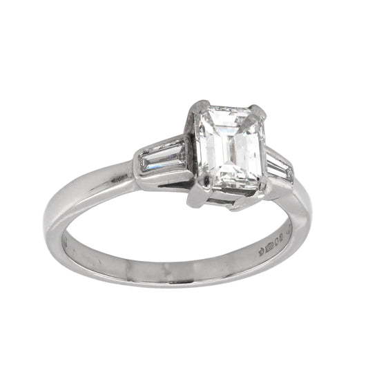 A three stone emerald and baguette cut diamond ring in platinum