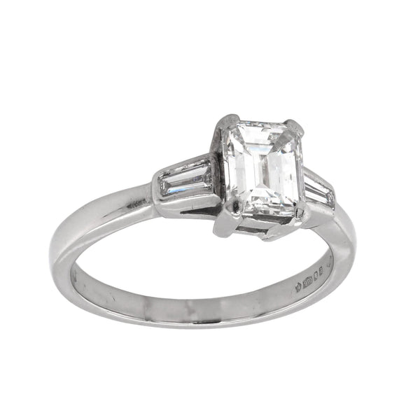 A three stone emerald and baguette cut diamond ring in platinum