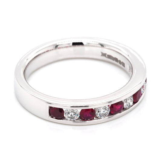 A platinum channel set half eternity ring with rubies and diamonds