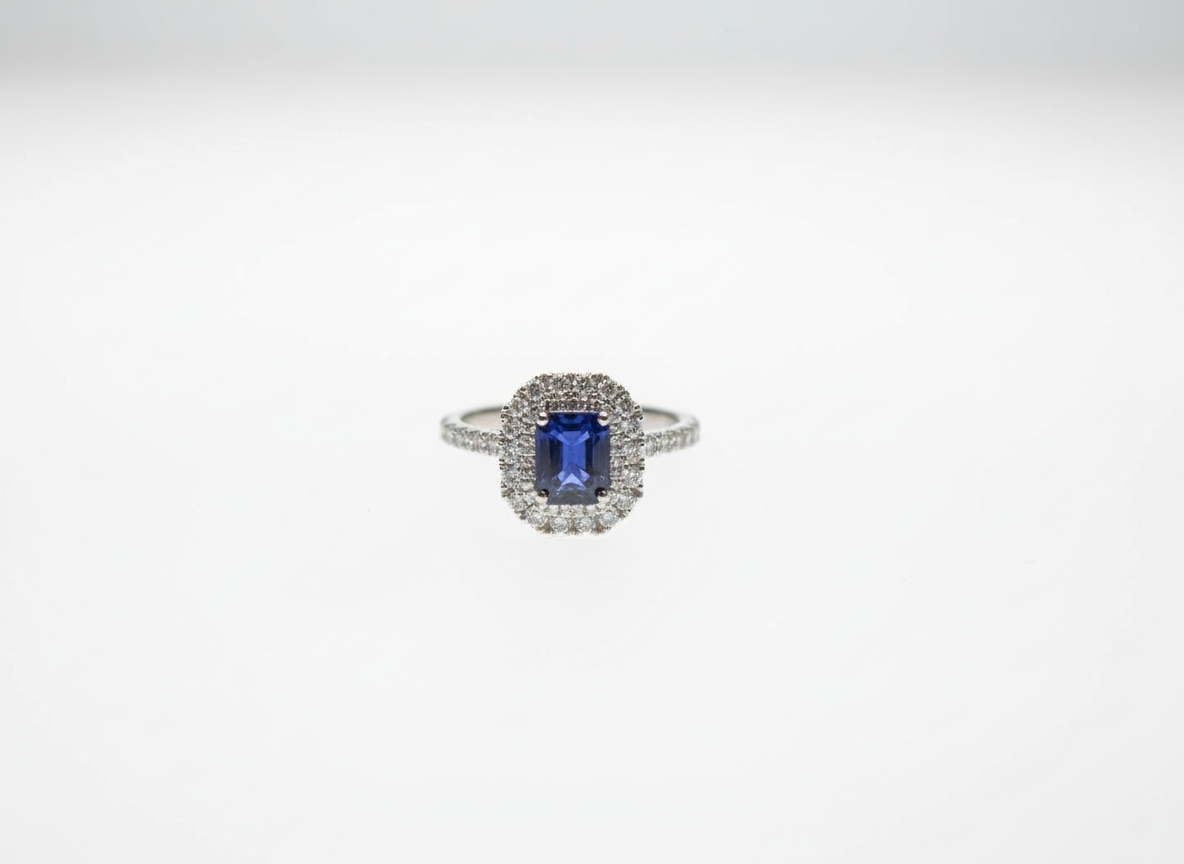 An emerald cut sapphire and brilliant cut diamond double halo cluster ring in platinum