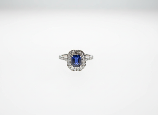 An emerald cut sapphire and brilliant cut diamond double halo cluster ring in platinum