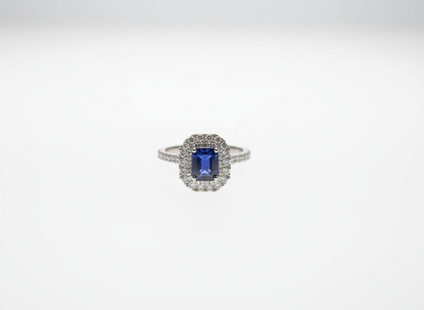 An emerald cut sapphire and brilliant cut diamond double halo cluster ring in platinum