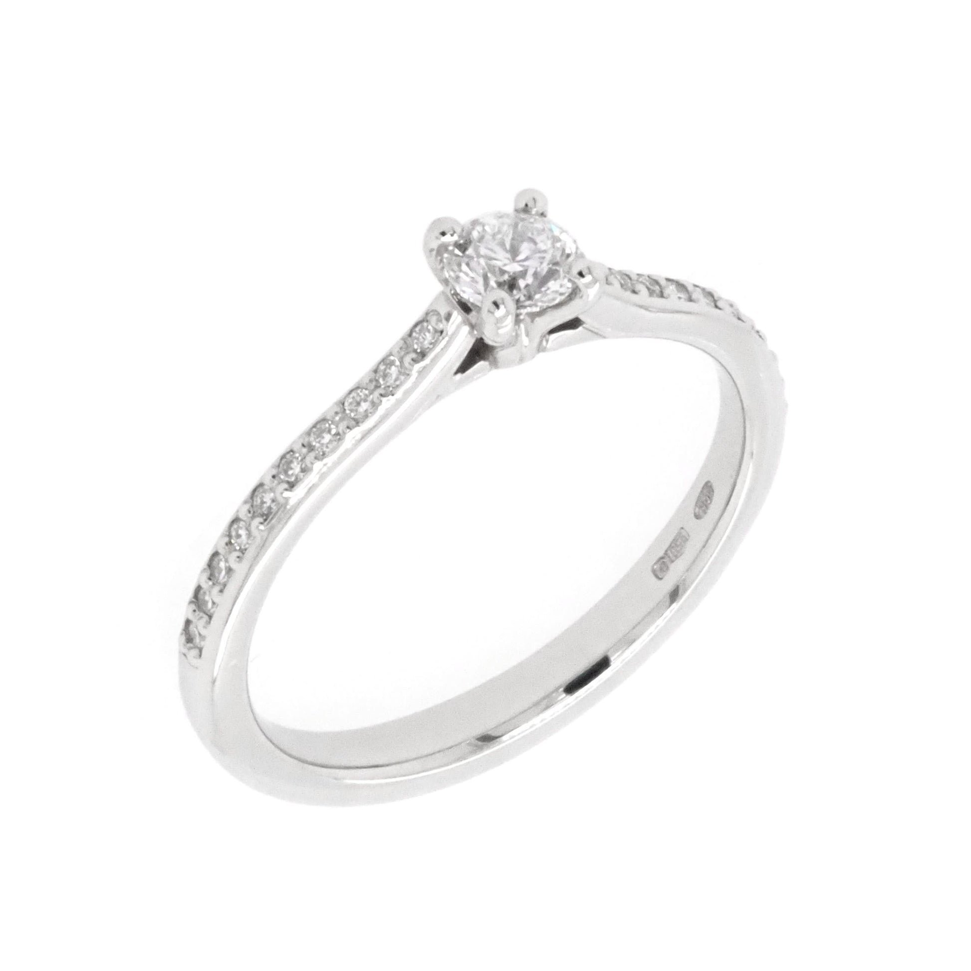 A platinum brilliant cut diamond solitaire ring with diamond set shoulders