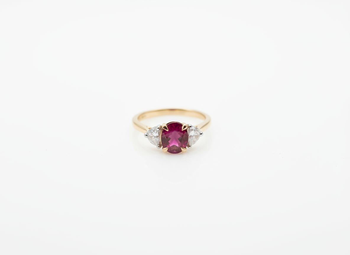 A yellow gold three stone ring with an oval ruby and two fancy cut diamonds